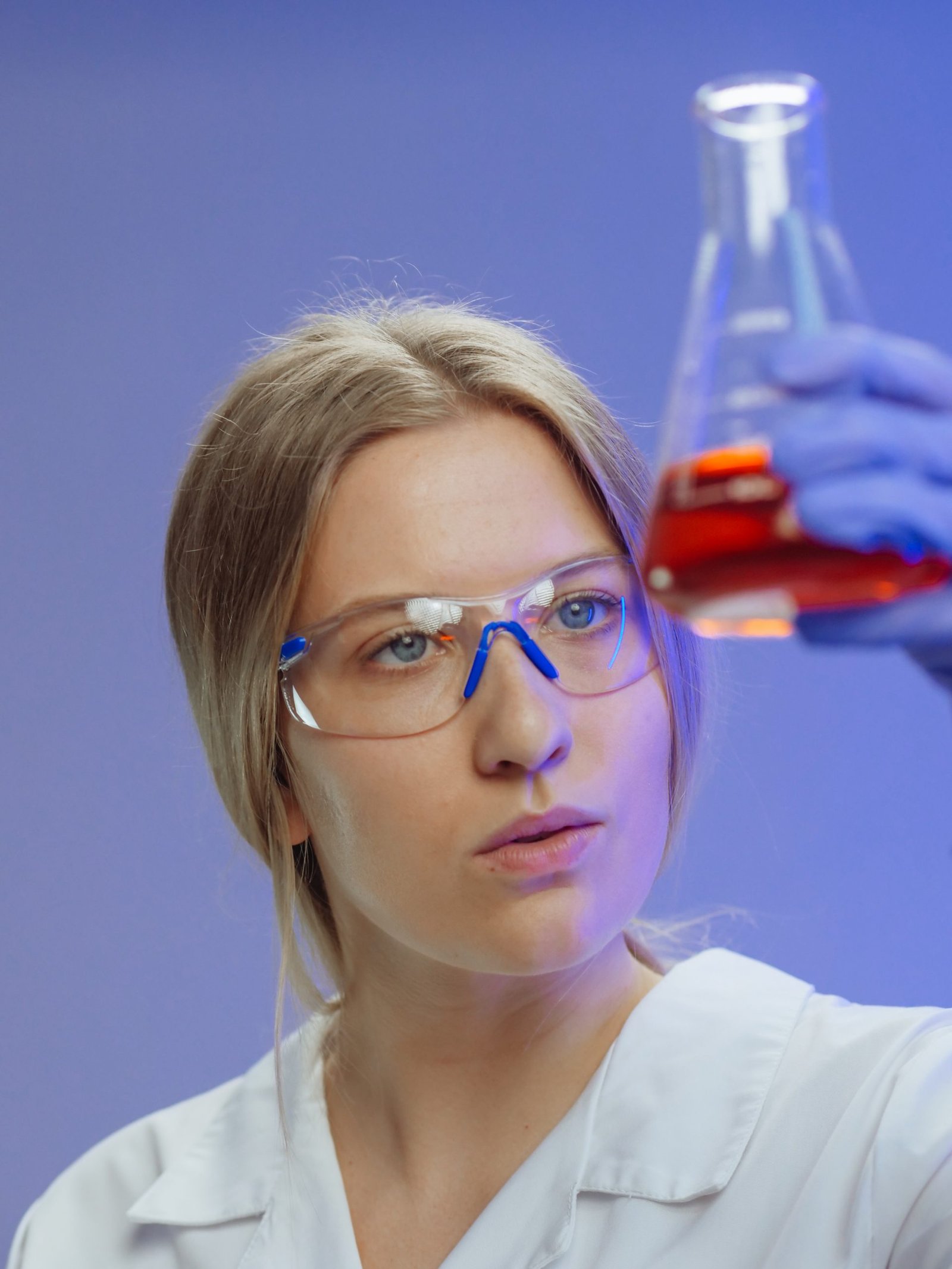 woman holding an erlenmeyer flask with red liquid stockpack pexels scaled