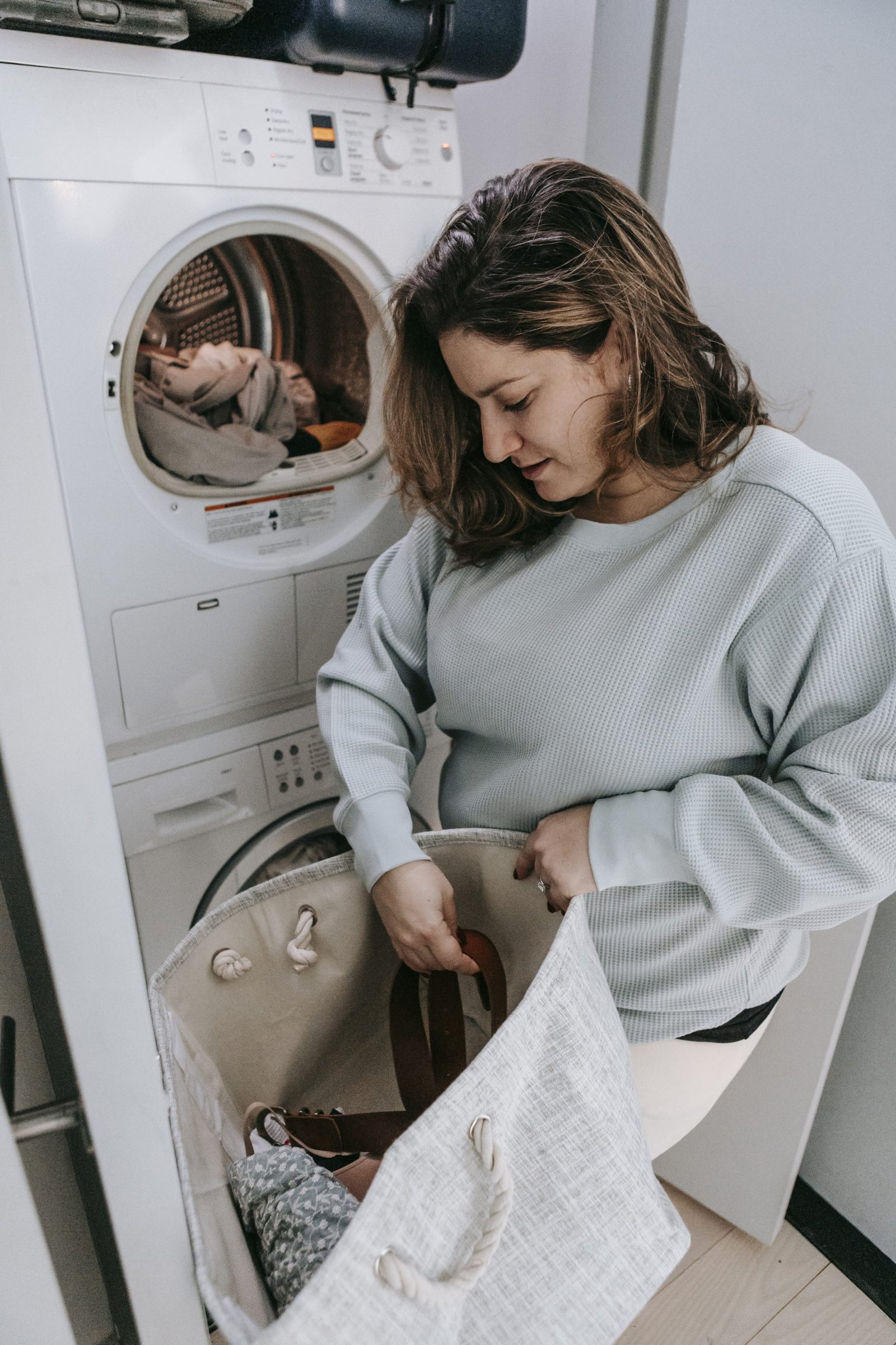 woman loading dirty clothes into washing machine stockpack pexels scaled